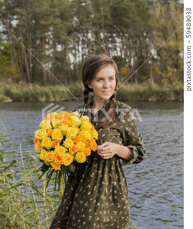 Beautiful girl with a bouquet of yellow roses. Effective woman near the river. Pretty Woman. Teen girl with yellow roses. Beautiful girl with a bouquet of yellow roses. Effective woman near the river. Pretty Woman. Teen girl with yellow roses. 59489038