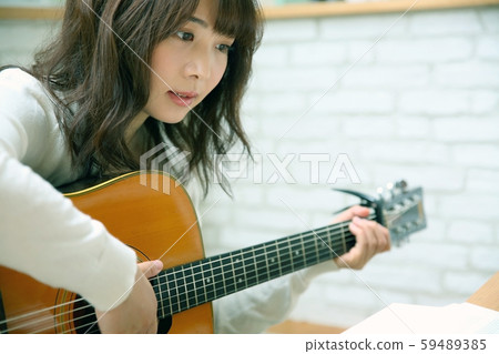 Image of woman playing acoustic guitar 59489385