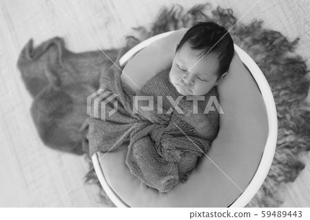 newborn baby wrapped in a blanket sleeping in a basket. concept of childhood, healthcare, IVF. Black and white photo newborn baby wrapped in a blanket sleeping in a basket. concept of childhood, healthcare, IVF. Black and white photo 59489443