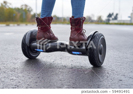 Close up of woman using hoverboard on asphalt 59491491