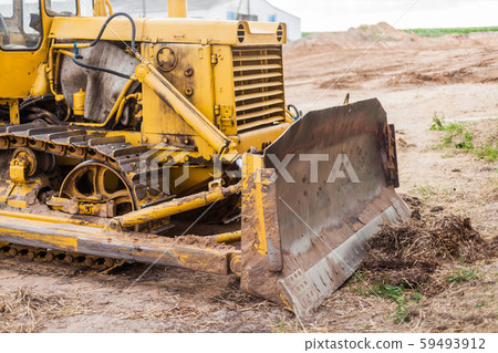 Yellow Tractor on crawler track. Close-up of crawler bulldozer truck. Earthmoving heavy machinery Yellow Tractor on crawler track. Close-up of crawler bulldozer truck. Earthmoving heavy machinery 59493912