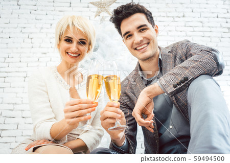 Couple clinking with sparkling wine for Christmas 59494500