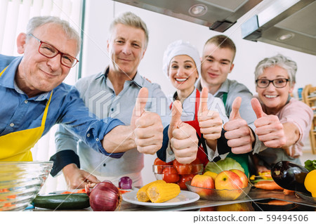 Trainees and their nutritionist in a training kitchen showing thumbs 59494506