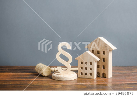 Wooden houses and a paragraph figurine with a judge gavel. Concept legislation on residential buildings and infrastructure. Standardization and construction of housing. Real estate legal services. 59495075