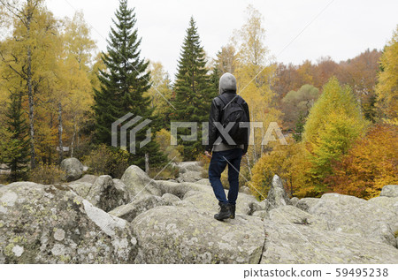 Young man on a volcanic stones in the mountain Young man on a volcanic stones in the mountain 59495238