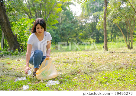 Asian cute girl help to clean the garden by pick the plastic garbage 59495273
