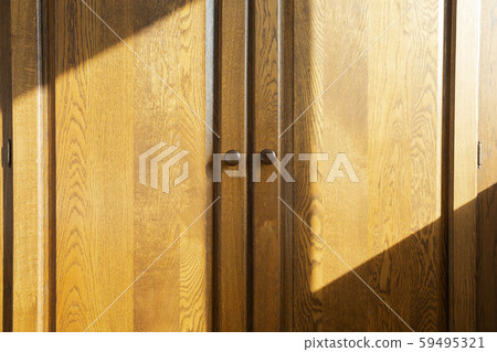 Brown wooden closet doors, oak luxury design beauty with sunlight and shadows 59495321