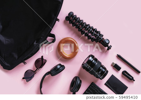 Contemporary black accessories and devices on pink background, overhead view Contemporary black accessories and devices on pink background, overhead view 59495410