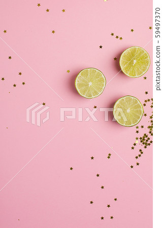 Lime with golden stars confetti on pink color paper background minimal style Lime with golden stars confetti on pink color paper background minimal style 59497370