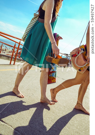 Girls walk on the sidewalk at Galway beach in Girls walk on the sidewalk at Galway beach in 59497427
