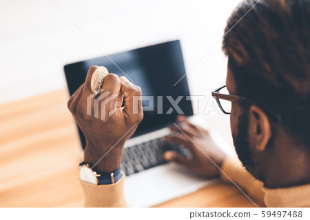 Close up of African American businessman holding bitcoin Close up of African American businessman holding bitcoin 59497488