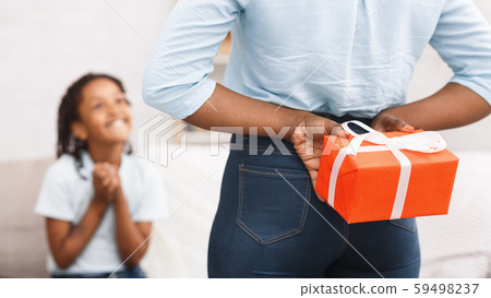 Mother hiding birthday present for daughter, making surprise 59498237