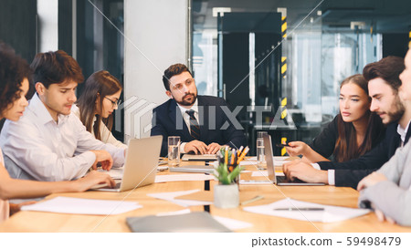 Young business team with male boss discussing work in office Young business team with male boss discussing work in office 59498479