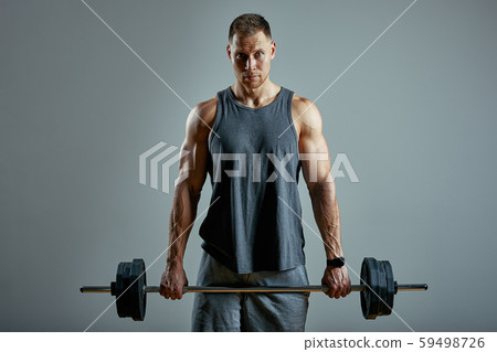 Man doing back workout, barbell row in studio over gray background. Copy space Man doing back workout, barbell row in studio over gray background. Copy space 59498726