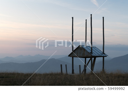 Picturesque autumn meadow with wooden construction for dry hay 59499992