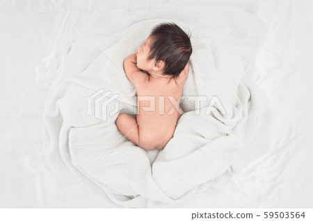 Baby sleeps on soft white blanket, Top view. 59503564