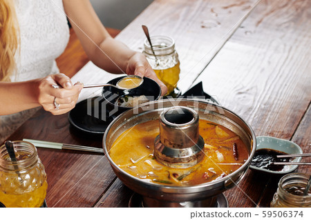 Yuong woman eating delicious squid soup 59506374