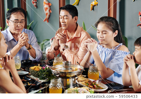 Family praying before dinner 59506433