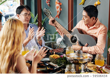 People clapping to friend playing guitar 59506434