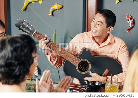Man playing guitar fro friends and relatives 59506435