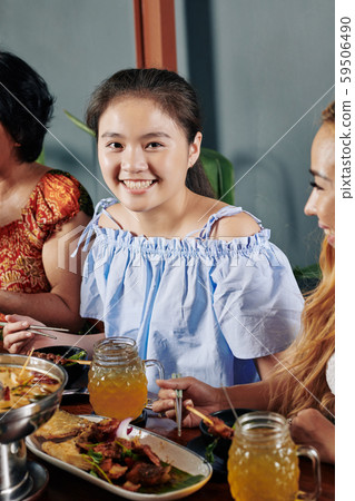 Happy Asian girl eating dinner Happy Asian girl eating dinner 59506490
