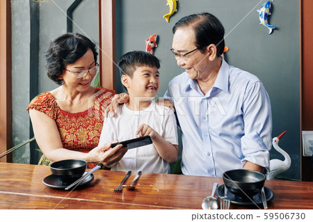 Cheerful boy at cafe with grandparents Cheerful boy at cafe with grandparents 59506730