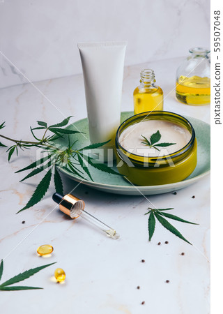 Cosmetics with cannabis oil on a turquoise plate on a light marble background. Copy space, mockup. Cosmetics with cannabis oil on a turquoise plate on a light marble background. Copy space, mockup. 59507048