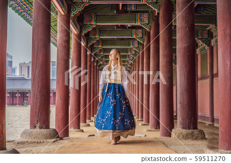 Young caucasian female tourist in hanbok national korean dress at Korean palace. Travel to Korea Young caucasian female tourist in hanbok national korean dress at Korean palace. Travel to Korea 59511270