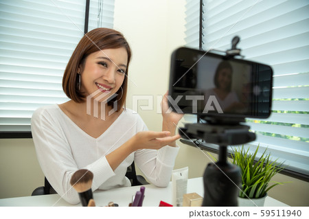 Asian woman beauty vlogger or blogger live broadcast of cosmetic makeup tutorial clip by mobile Asian woman beauty vlogger or blogger live broadcast of cosmetic makeup tutorial clip by mobile 59511940