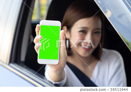 Asian woman driver sitting in the car and holding phone Asian woman driver sitting in the car and holding phone 59511944