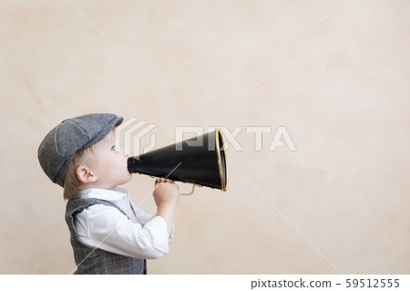 Kid shouting through vintage megaphone 59512555