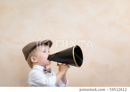 Child shouting through vintage megaphone 59512612