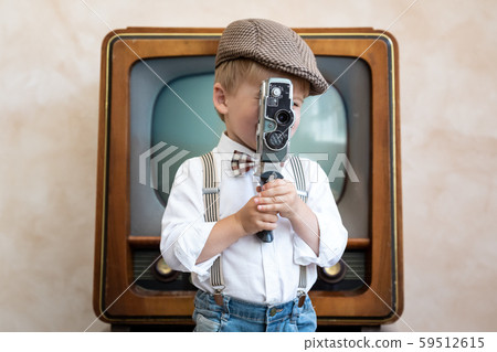 Funny kid holding vintage camera 59512615