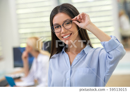 Beautiful woman smiling broadly after buying glasses at the weekend 59513015
