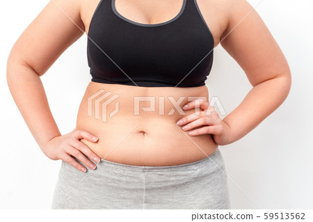 Body Care. Chubby girl with bare belly standing isolated on white hands on hips close-up 59513562
