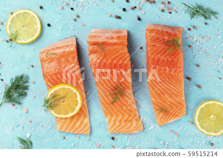 Slices of salmon with lemon and dill, overhead shot with salt and pepper on a blue background Slices of salmon with lemon and dill, overhead shot with salt and pepper on a blue background 59515214