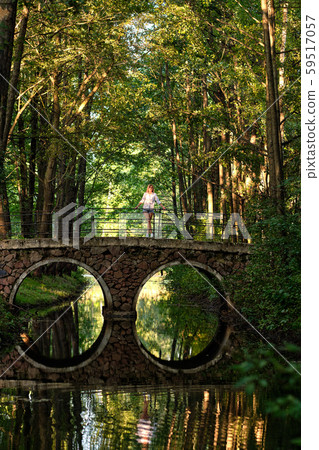 Vertical photo from long distance of girl on bridge Vertical photo from long distance of girl on bridge 59517057