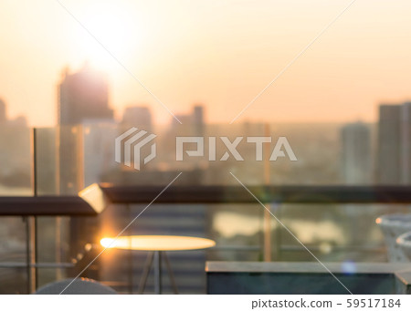 Blur abstract background city morning gold light sky rooftop view over cityscape with bright sun flare and bokeh 59517184