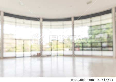 Blur background interior view looking out toward to empty office lobby and entrance doors and glass curtain wall Blur background interior view looking out toward to empty office lobby and entrance doors and glass curtain wall 59517344