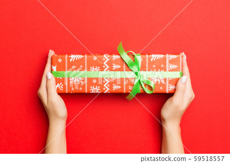 Female's hands holding striped gift box with 59518557