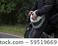 Driver riding motorcycle on an asphalt road through forest. 59519669
