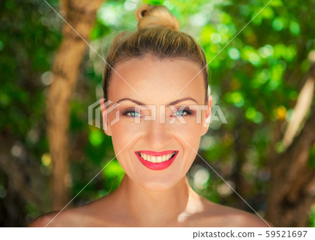 Face of young beautiful girl smiling, closeups short on nature green background 59521697