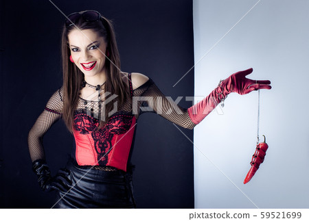 the girl in the red corset laughs and keeps on the chain of red pepper. Conceptually. Erotic game. the girl in the red corset laughs and keeps on the chain of red pepper. Conceptually. Erotic game. 59521699
