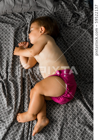 Sleeping baby with cloth diaper. Top view. Ecology reusable organic diaper. Copy space Sleeping baby with cloth diaper. Top view. Ecology reusable organic diaper. Copy space 59522137