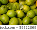 Pile of fresh green yellow limes at market for 59522869