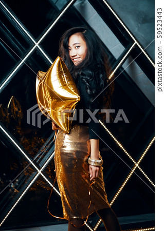 Portrait of pretty happy asian woman having fun and holding golden balloon 59523443