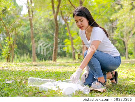 Asian cute girl help to clean the garden by pick the plastic garbage 59523596