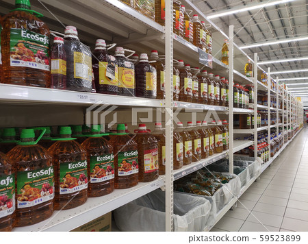 Cooking oil made from processed palm oil displayed for sale inside the supermarket. Sorted by the brand to make easy for the customer to choose.  59523899