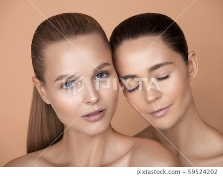 Portrait of beautiful young women isolated on brown studio background 59524202