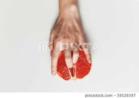 Sexual and female genital concept. Grapefruit and women's fingers like vagina and clitoris symbol 59526397